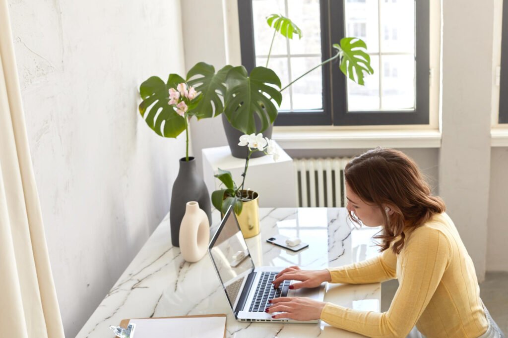 mujer en computador desde la casa