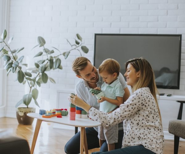 Niño Pequeño Jugando Con Juguetes En El Salón Con Su Padre Y Madre